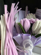 Bouquet of artificial flowers with pink and purple hues on a dark background