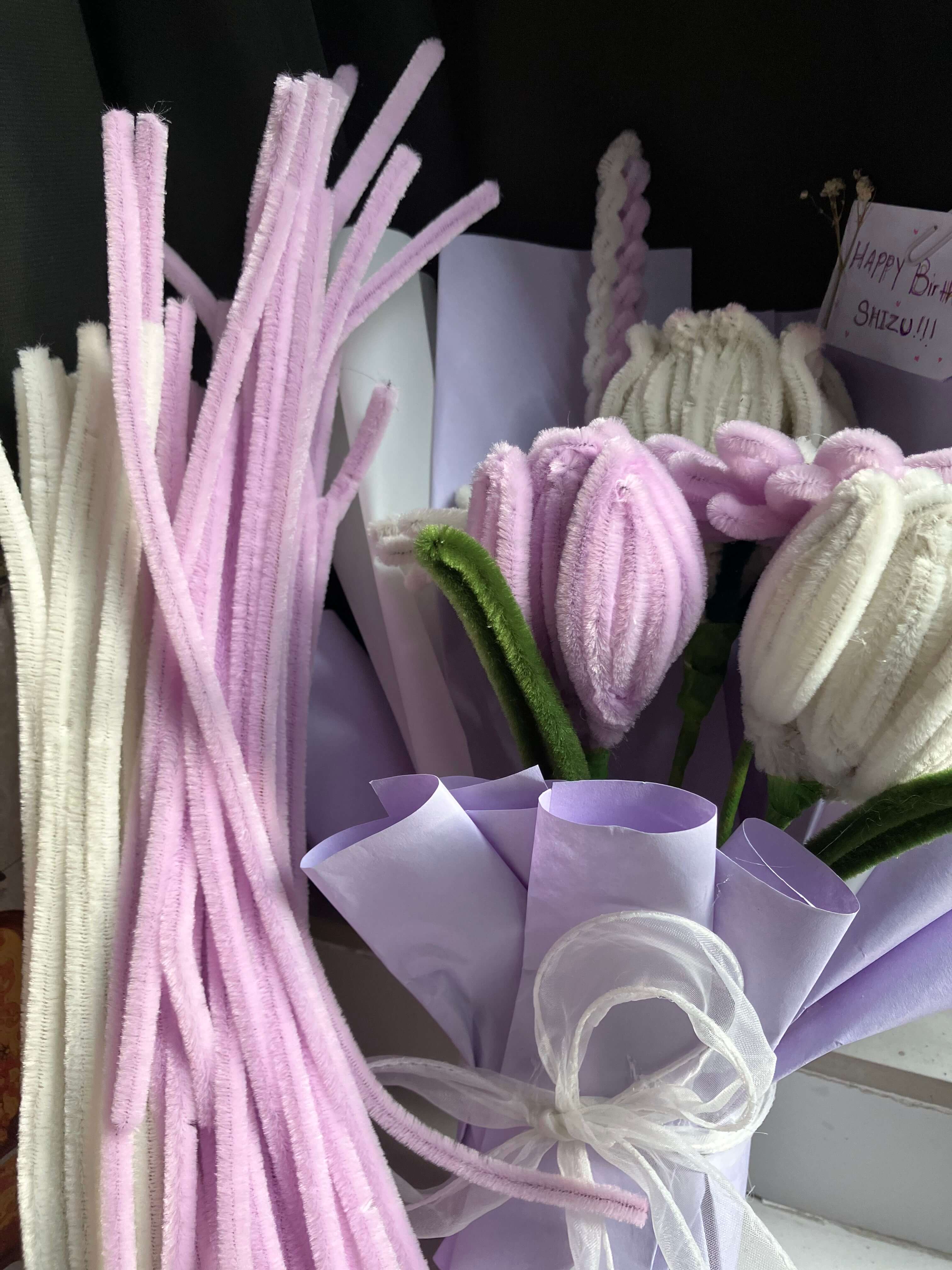 Bouquet of artificial flowers with pink and purple hues on a dark background