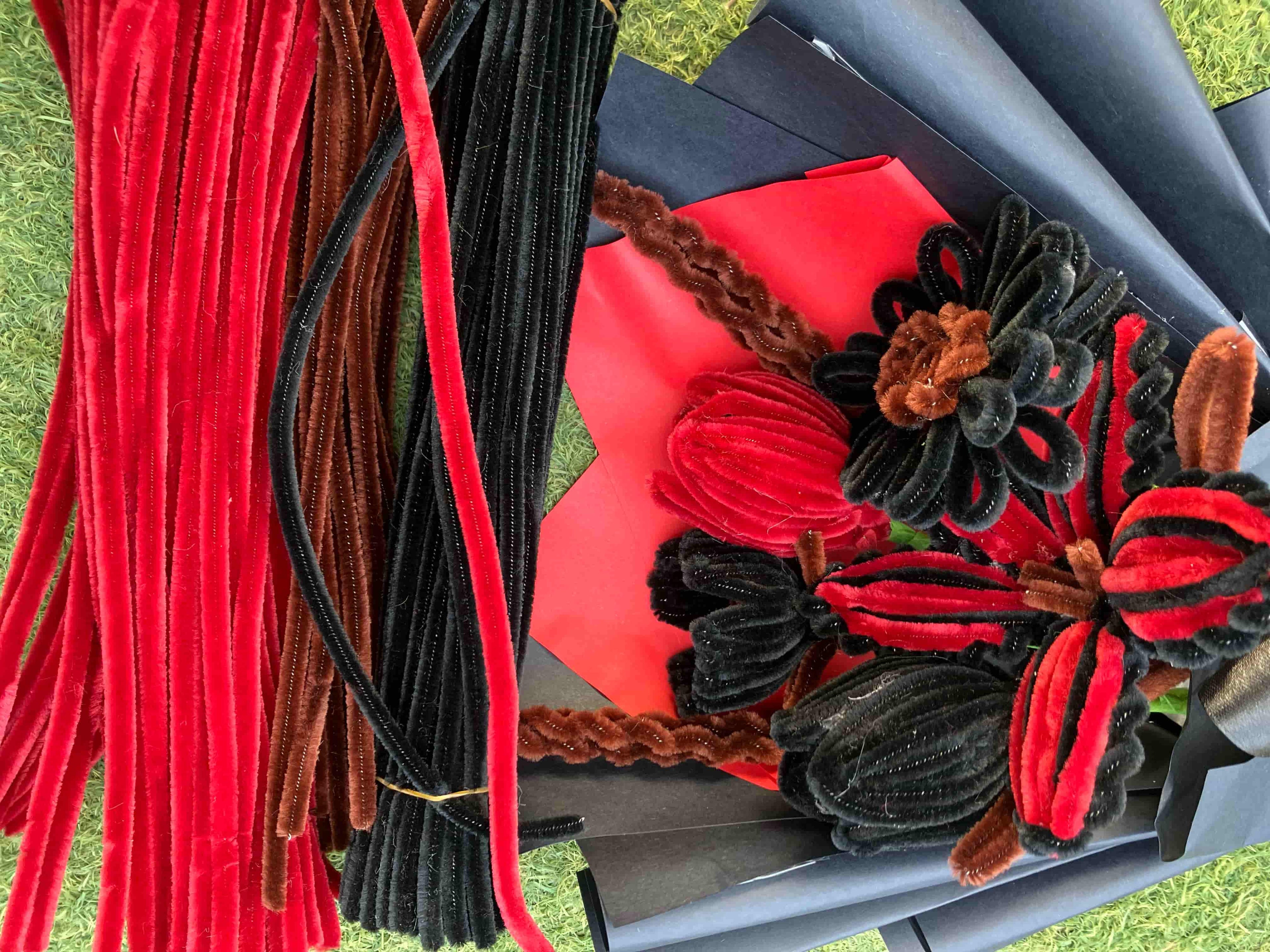Decorative wreath with red and black flowers on a car seat.