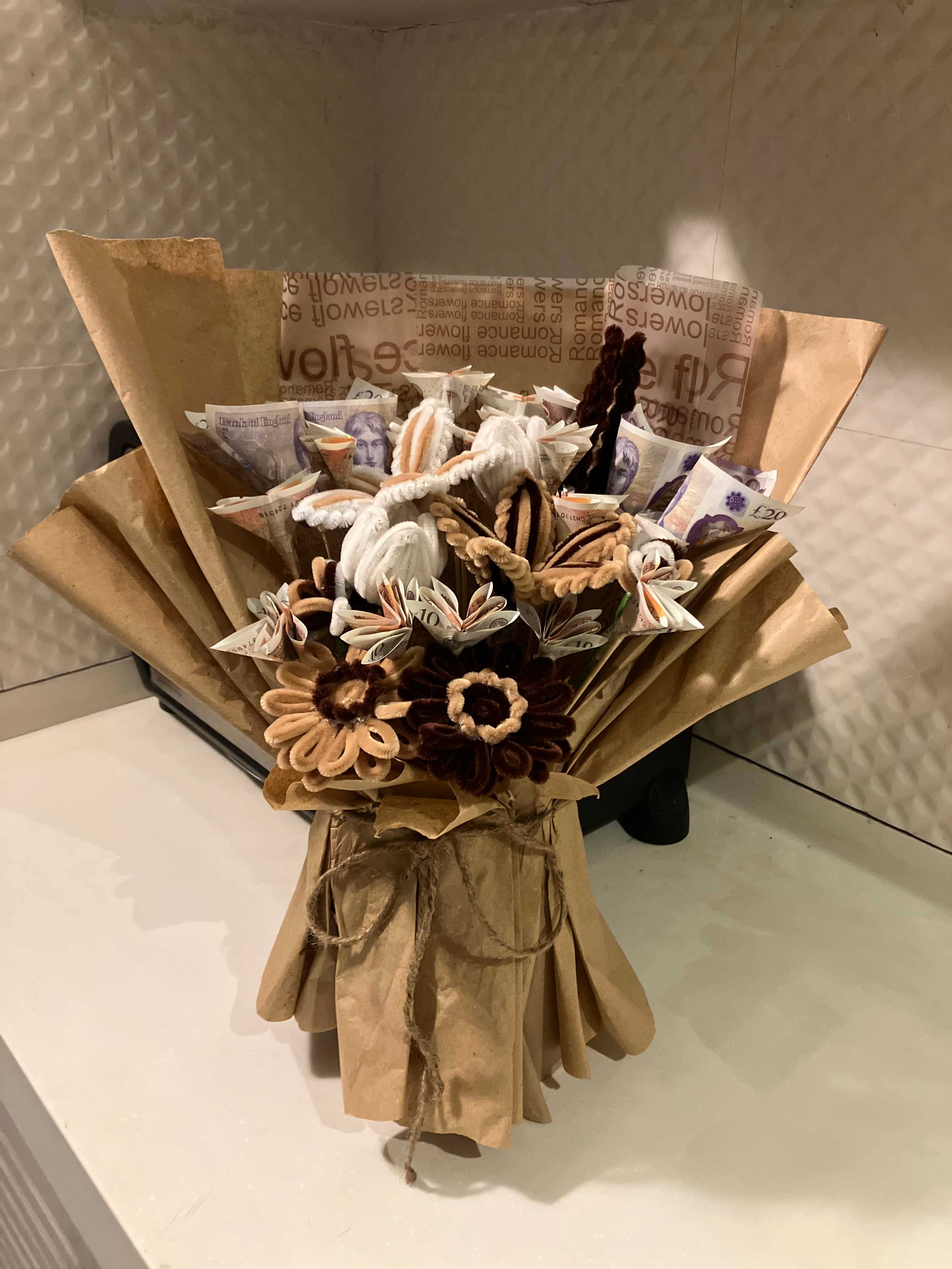Bouquet of flowers wrapped in brown paper on a textured surface