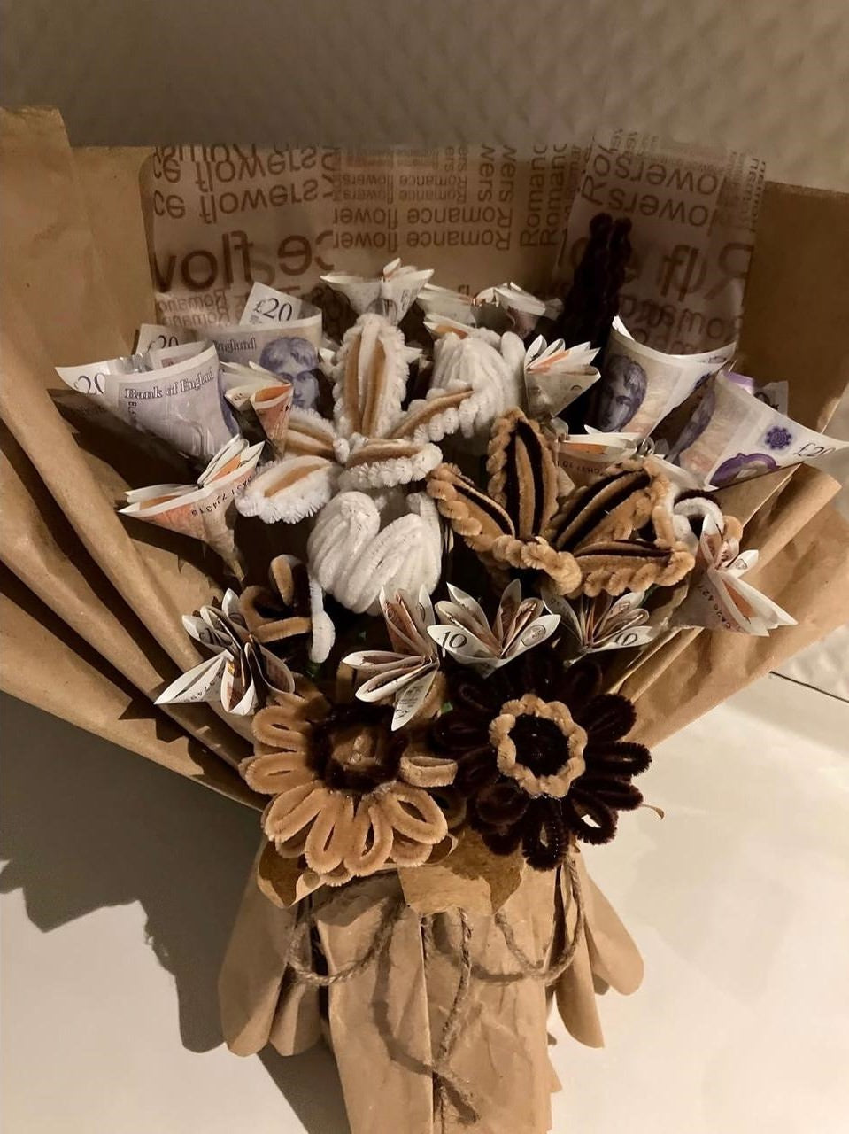 Bouquet of artificial flowers wrapped in brown paper with newspaper-like texture