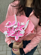 Person holding a bouquet of pink flowers with white accents