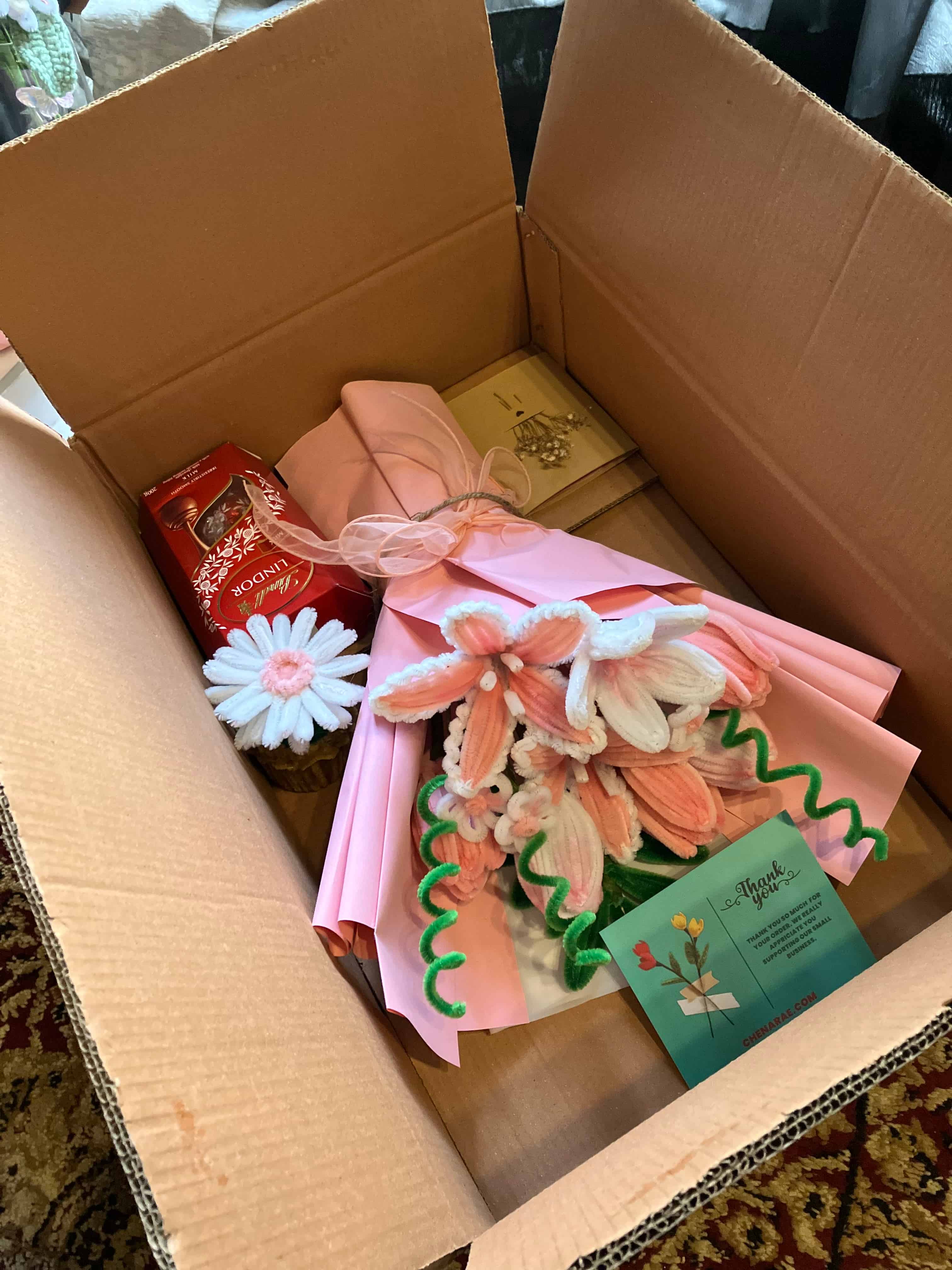 Bouquet of cookies in a box with a card on a textured surface