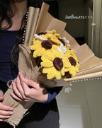 Person holding a bouquet of sunflower-shaped candles wrapped in brown paper.