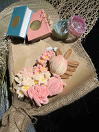 Bouquet of soap flowers on a textured surface with decorative boxes and containers.