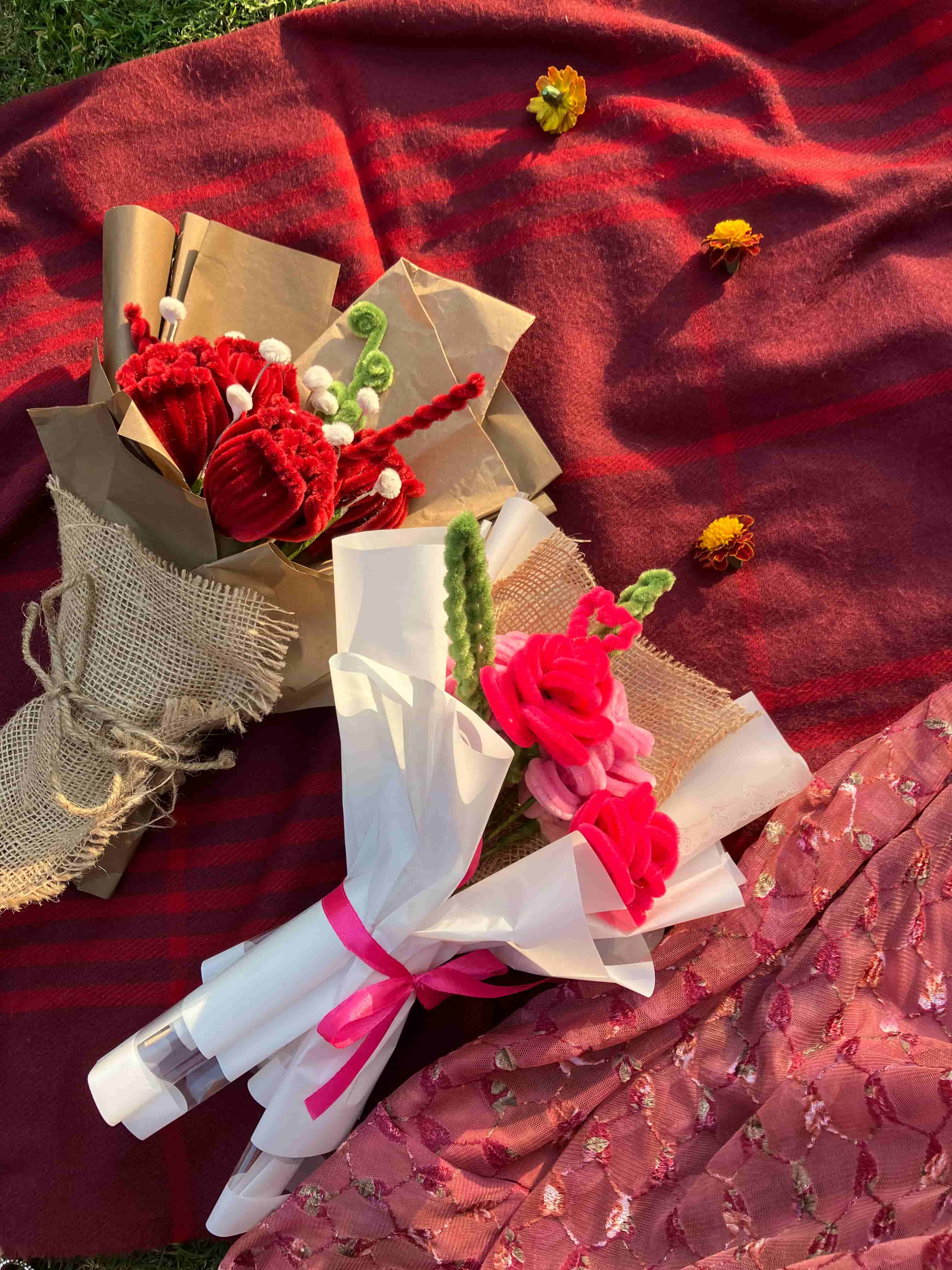 Bouquet of flowers and gift wrapped items on a red fabric background