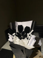 Bouquet of black and white flowers on a dark surface