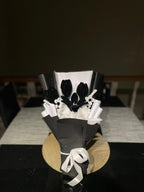 Decorative black and white flower arrangement on a table with a dark background