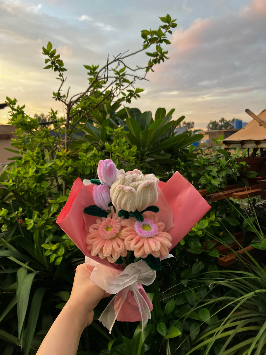Bouquet of flowers held by a hand with a blurred natural background