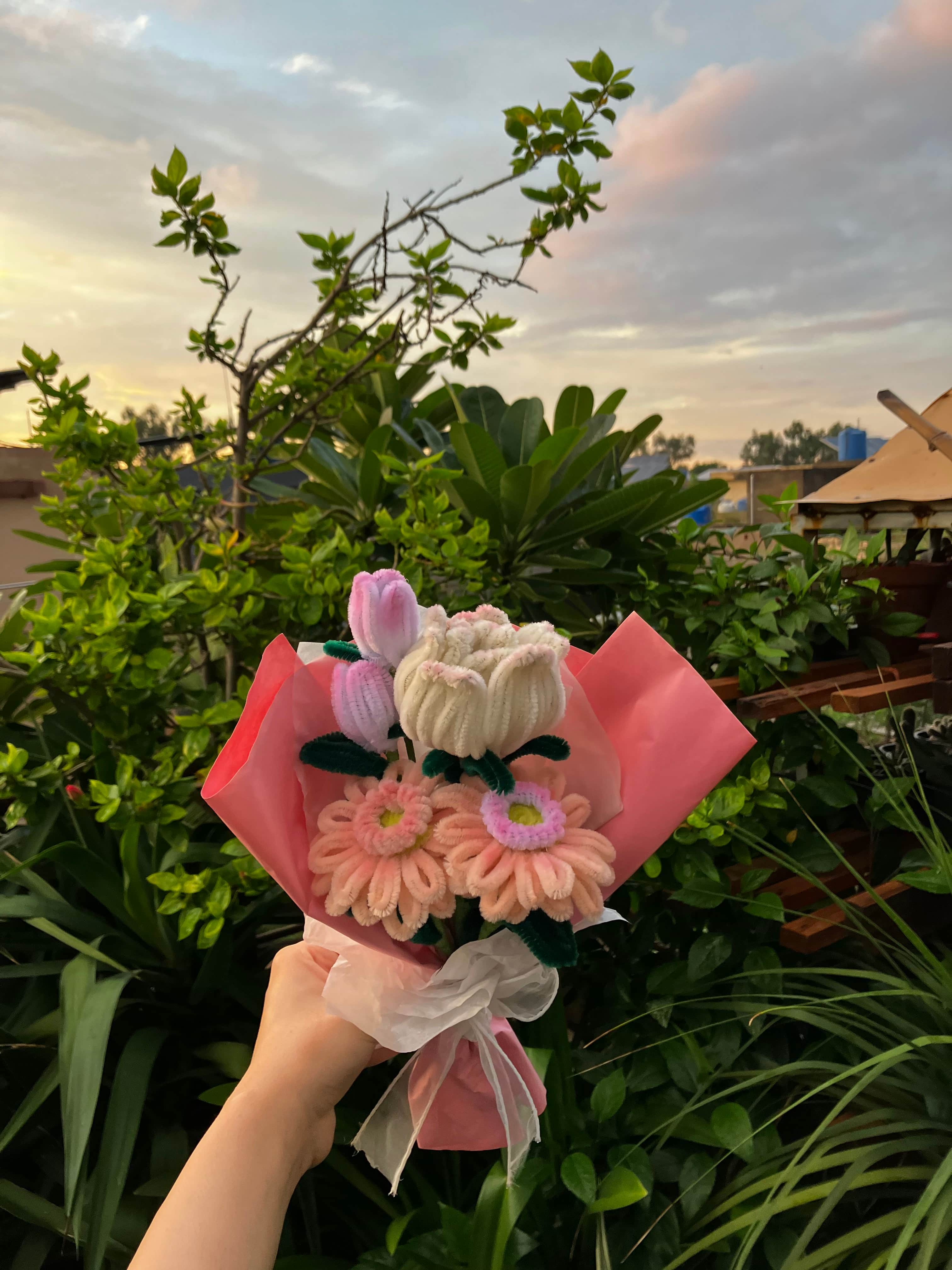 Bouquet of flowers held by a hand with a blurred natural background