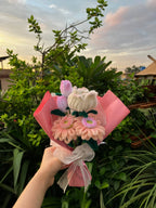 Bouquet of flowers held by a hand with a scenic background
