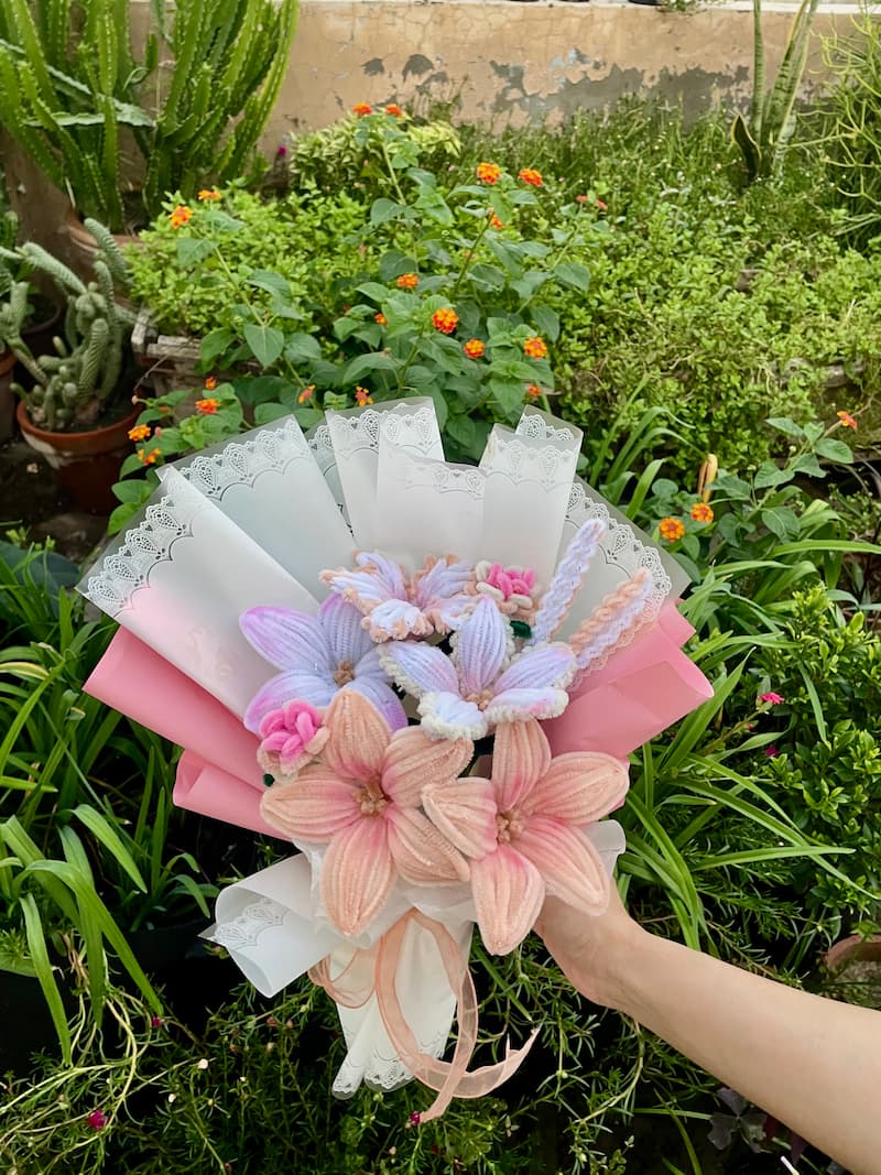 Bouquet of flowers held in front of a garden background