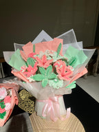 Bouquet of cookies shaped like flowers and butterflies on a table.