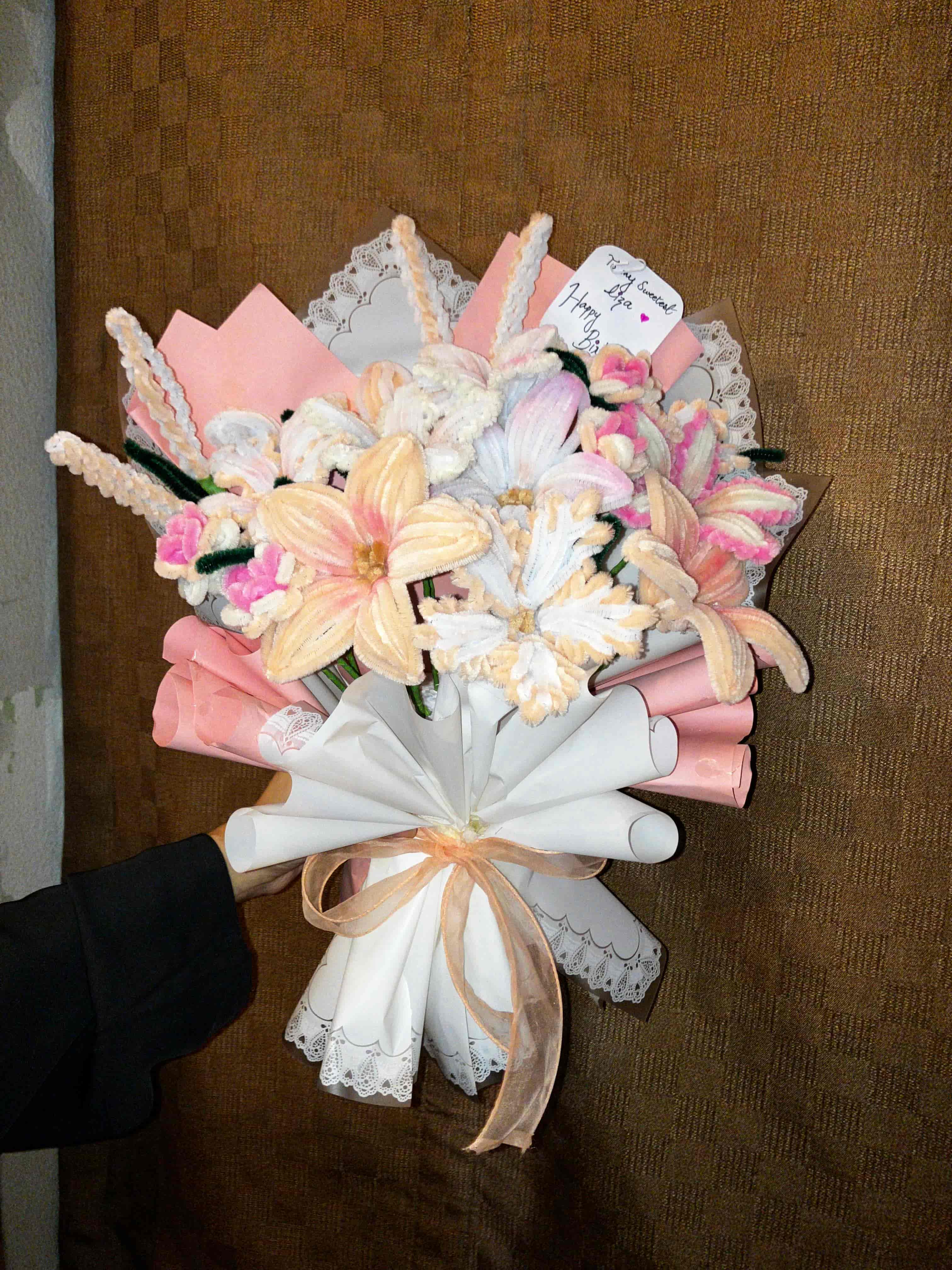 Bouquet of decorative ribbons and flowers on a brown surface