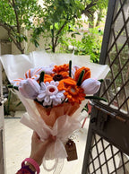 Bouquet of flowers with a tag held by a person outdoors.