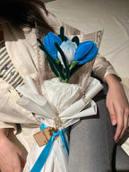 Bouquet of blue and white flowers with a tag on a newspaper background